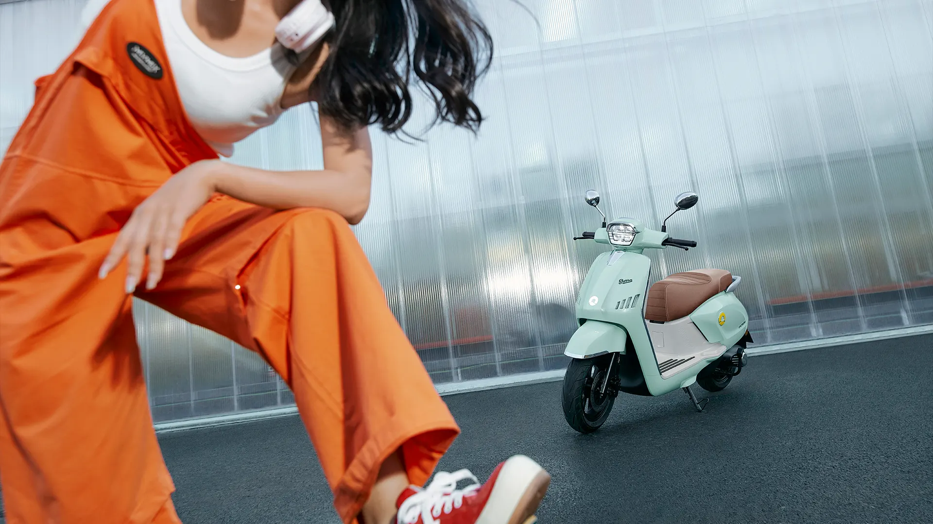 Fahrerin im orangen Overall mit einem Sunra Future Sport